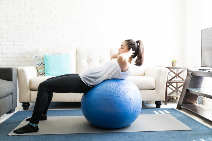 En kvinna som tränar core med en pilatesboll