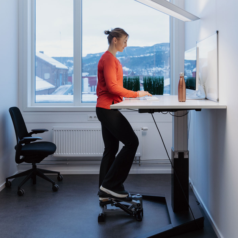 En tjej som trampar på sin stepmaskin på kontoret