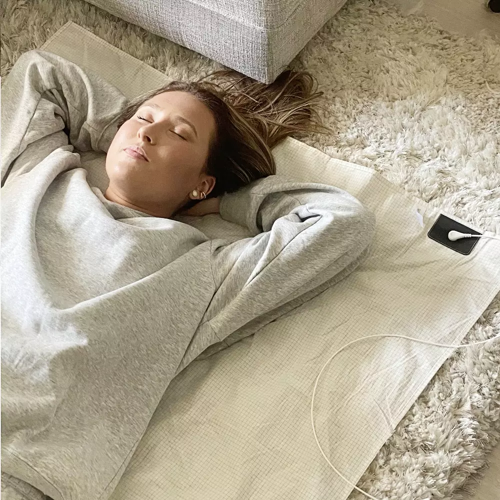 En tjej som sover gott på ett jordningslakan