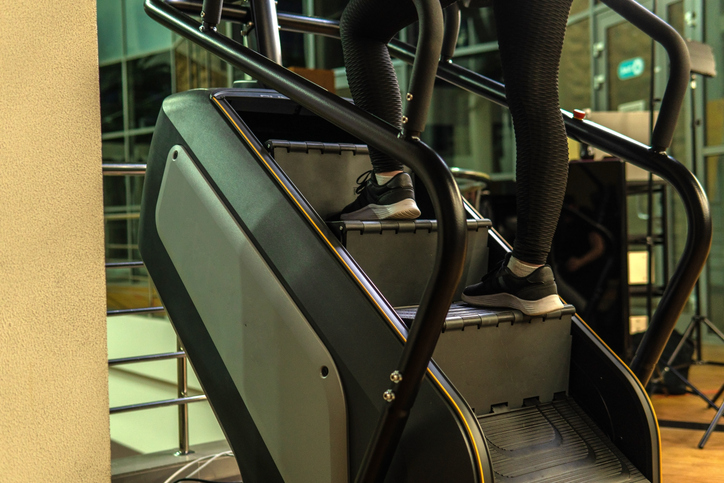 En tjej som tränar i en stair climber på gym
