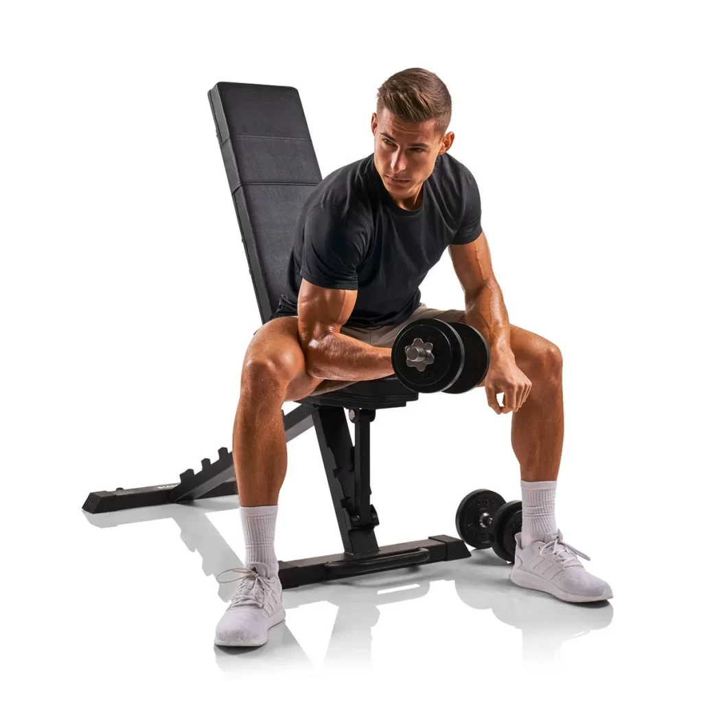 En man som gör bicepcurls på en träningsbänk