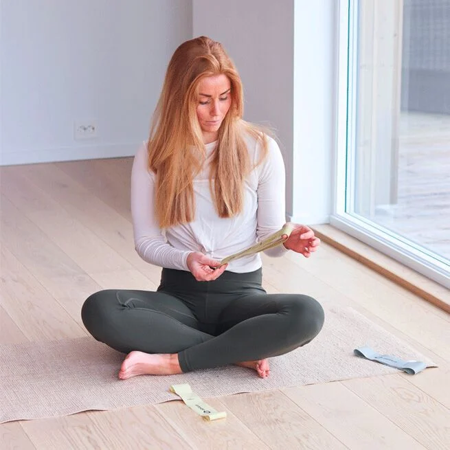 En tjej som precis köpt gummiband för träning hemma