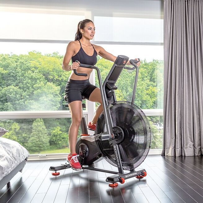 En tjej som cyklar på en Schwinn Airdyne hemma