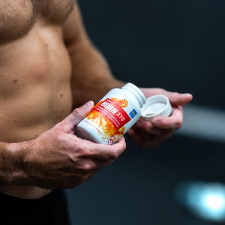 En man som tar fettförbränningstabletter på gymmet