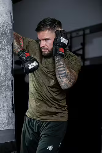 En man som tränar med MMA Handskar på boxningssäck