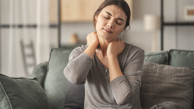 En kvinna som har ont i nacken och skulle behöva en nackmasserare