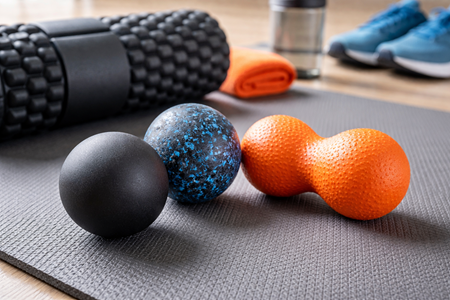 Flera olika massagebollar på en träningsmatta