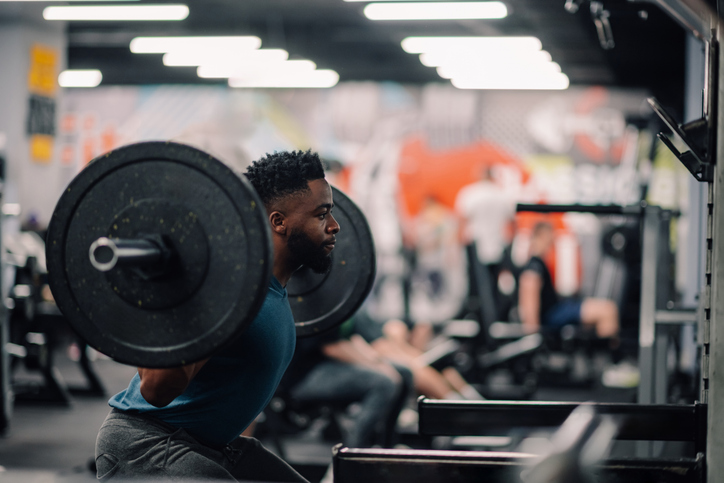 En kille som gör knäböj