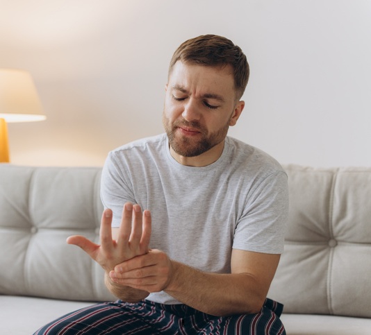 En man som är stel i händerna och funderar på att köpa en handmassagemaskin