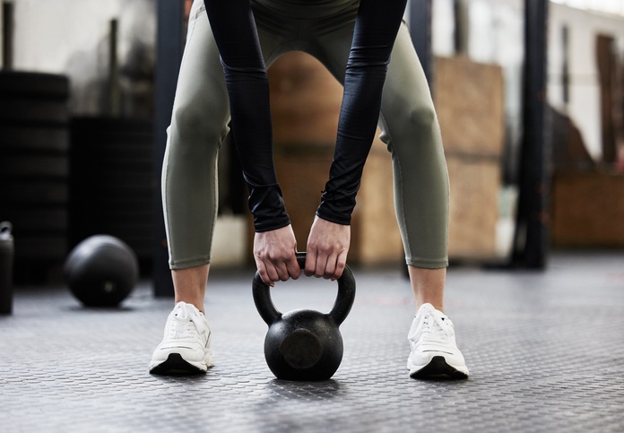 En kvinna med en kettlebell på gymmet